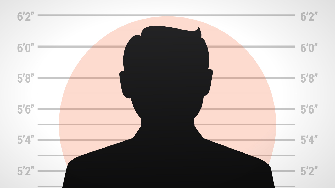 The silhouette of a personal against a criminal line up height backdrop.